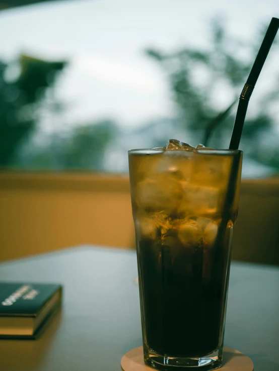 a drink with a straw is in a glass on a table