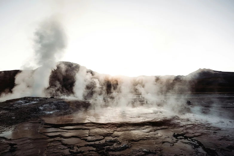 a steaming pool in a rock with snow on the ground