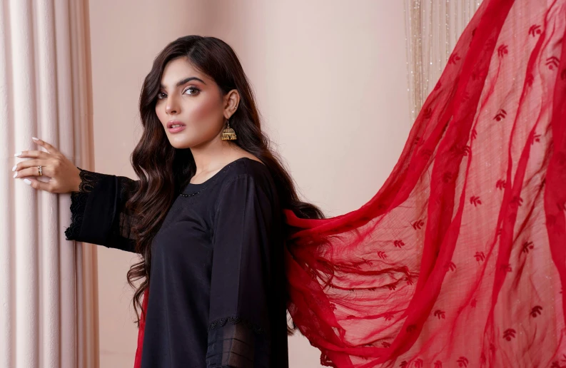 woman posing for pograph holding red scarf in hand