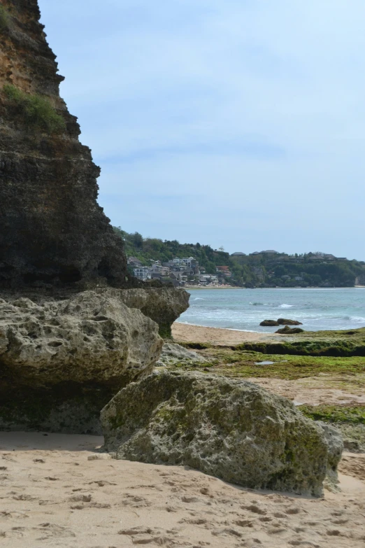 a lone bench on the beach near some rocks