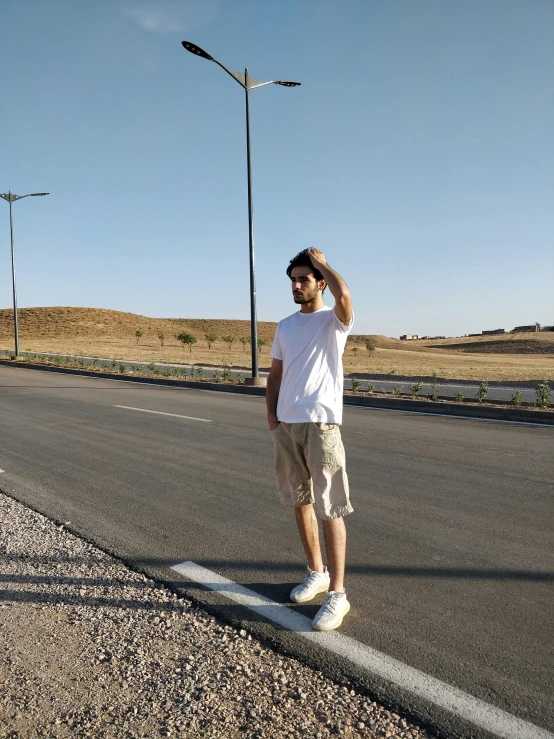 man in sunglasses is standing on the side of the road