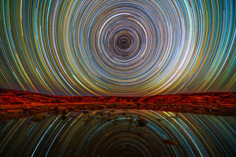 star trails are seen over water in this image