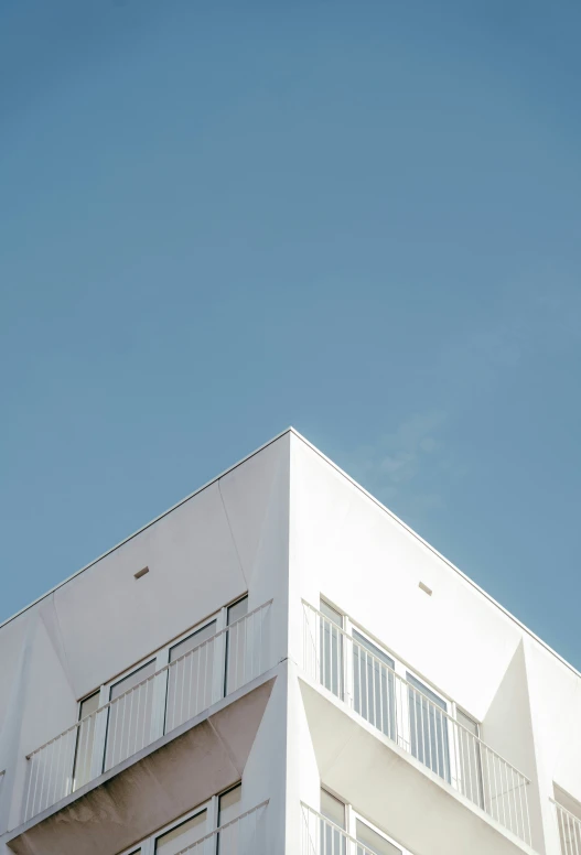 a tall white building with many balconies on top