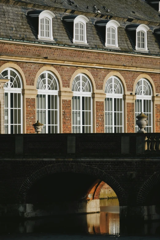 a building with many windows and arched arches is reflected in the water