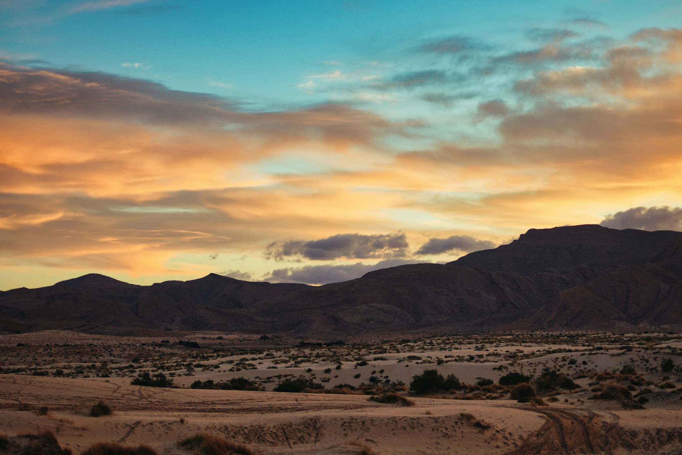 a beautiful sunset over some very desert hills