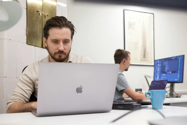 a man is sitting at his laptop and looking up