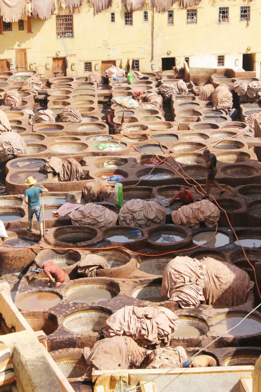 many large bowls and small containers filled with dirty water