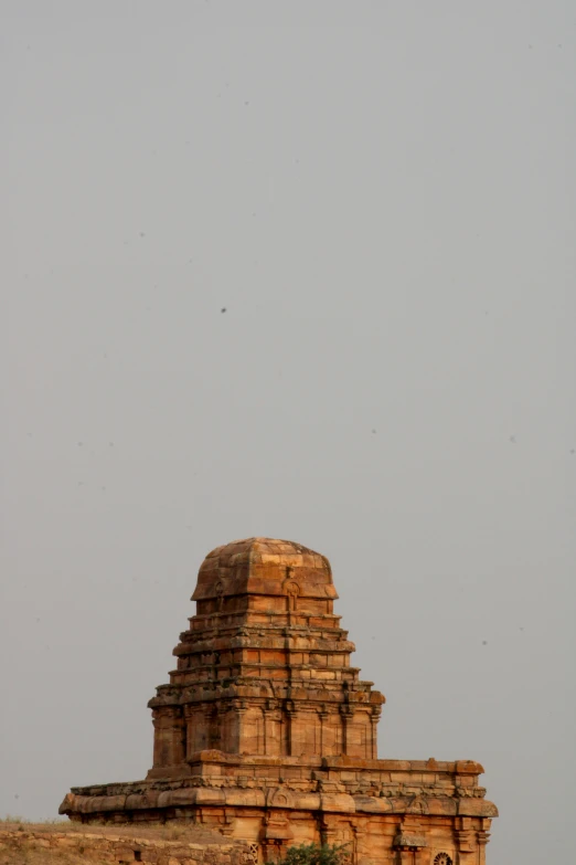 a very tall stone tower near an old building