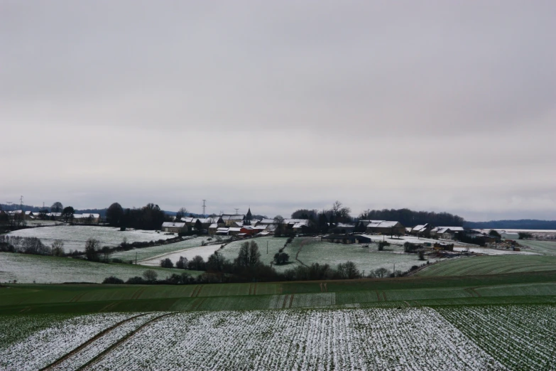 the view from above the landscape of houses, a farm, and a field