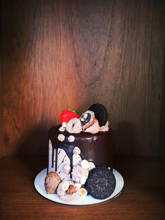 a cake decorated with cookies and a strawberry sitting on a plate