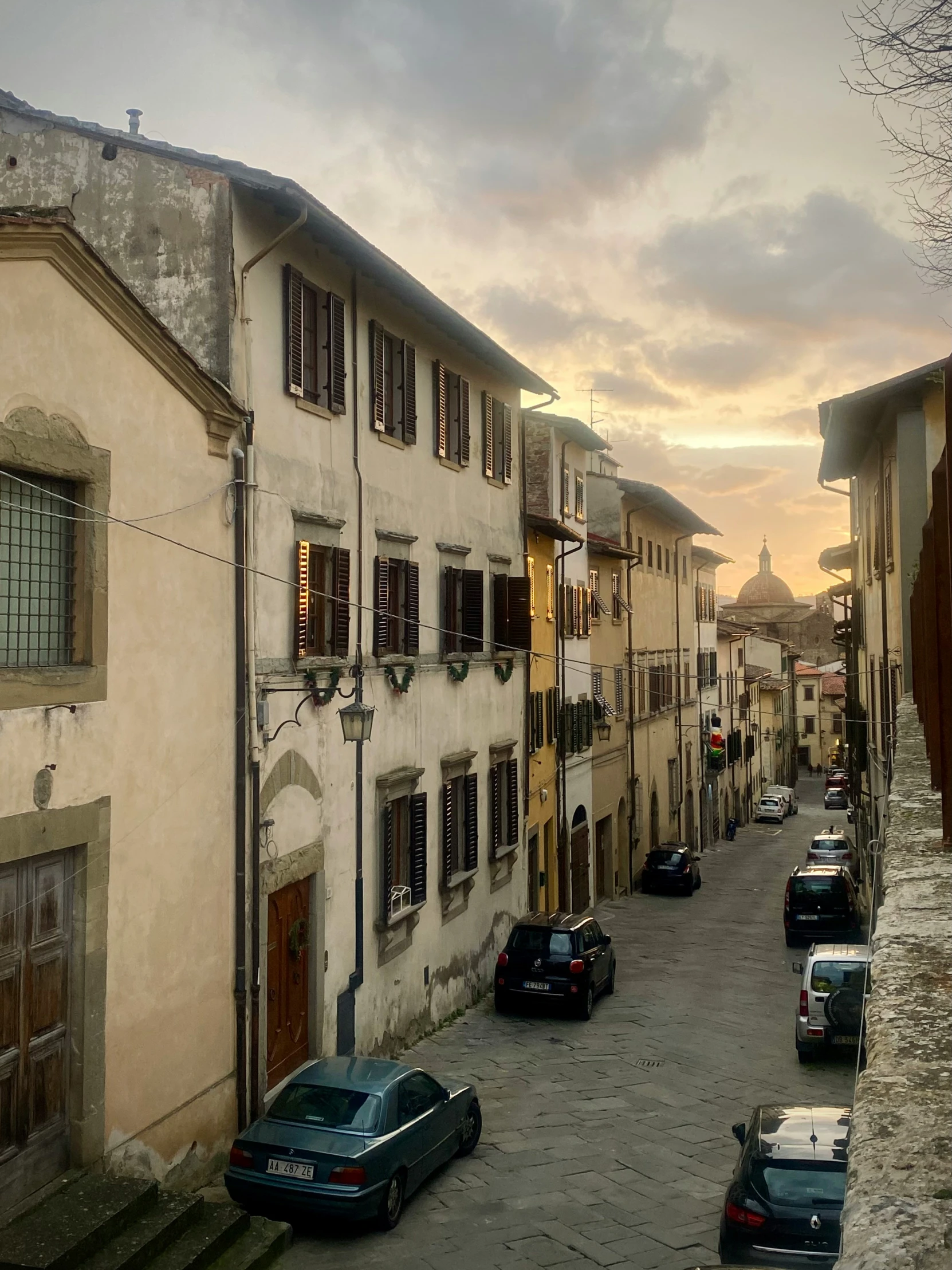 a row of tall houses with cars parked near them