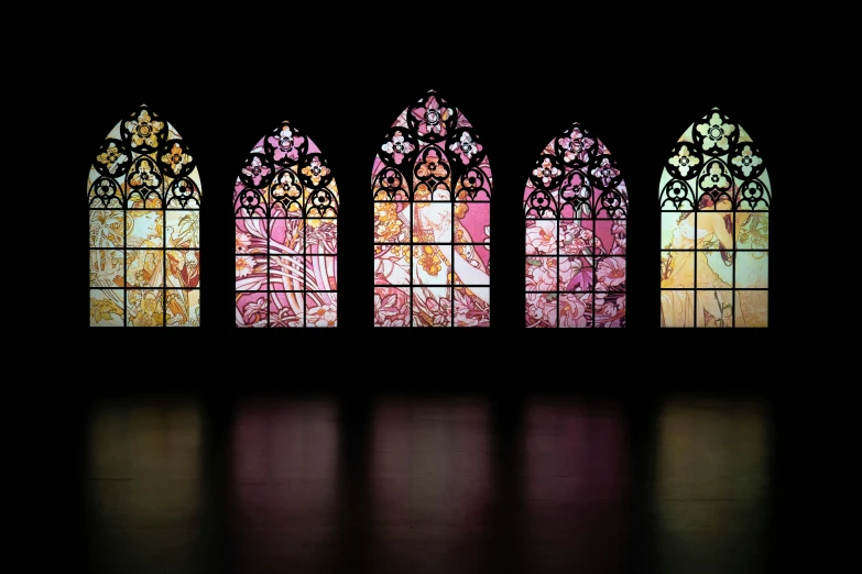 a dark room with stained glass windows in each