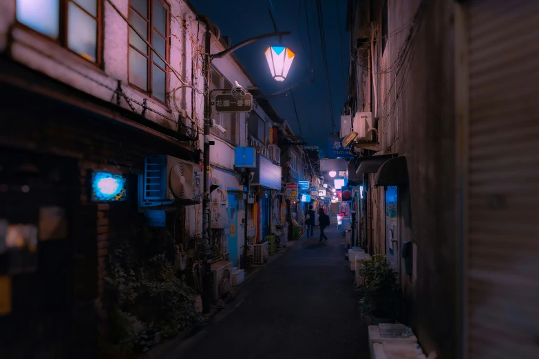 a city street at night with people walking on the sidewalk