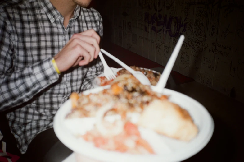 a man sitting in front of food covered plate