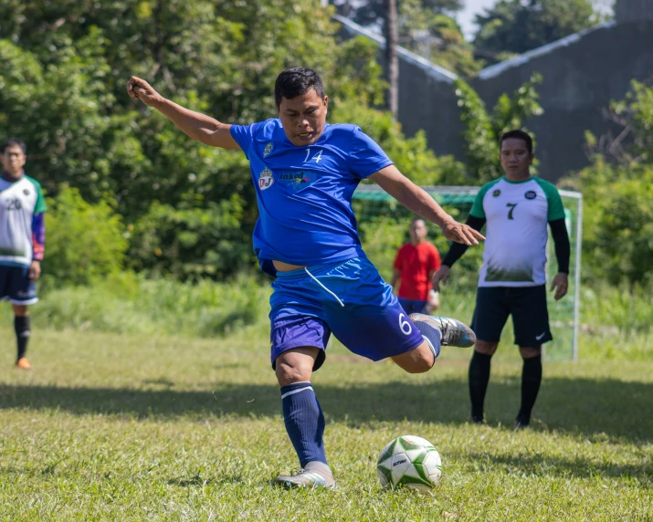 the soccer player is kicking the ball down a field