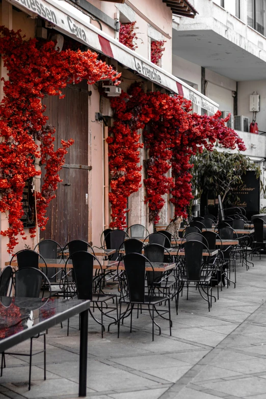 a row of black tables sitting outside of a restaurant