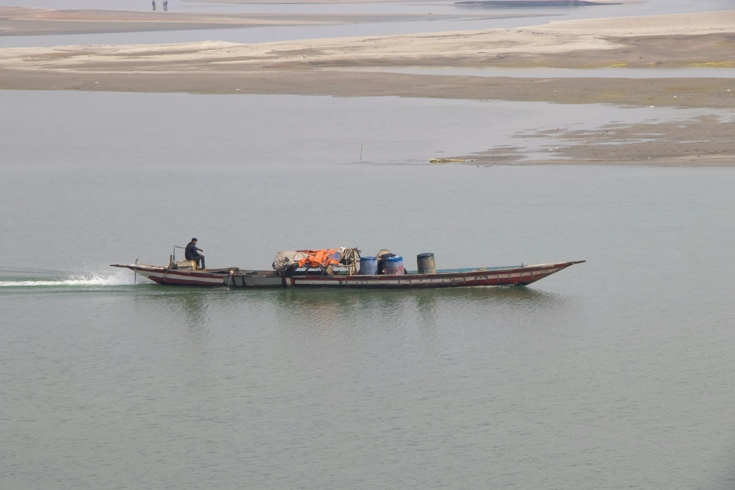 man on a long boat near a beach