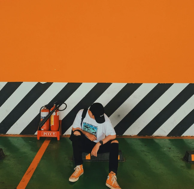 a man sitting on the ground while holding a tennis racket