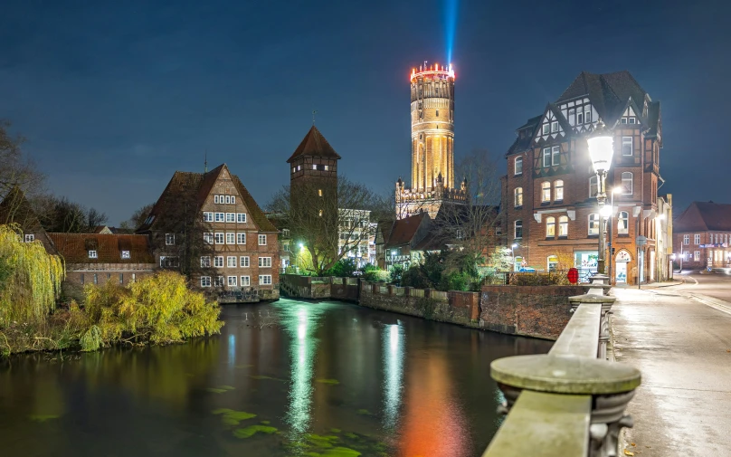 the water is reflecting the tower at night