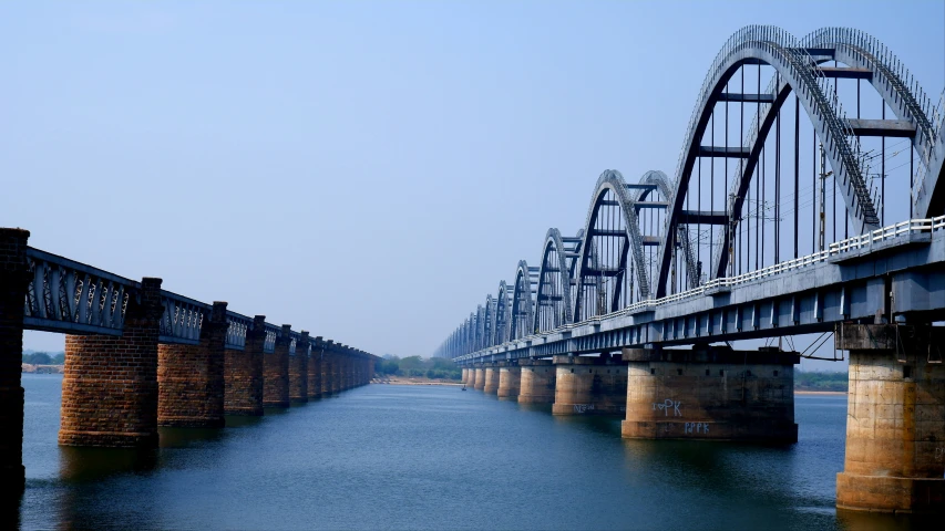 the long bridge is being passed over a large body of water