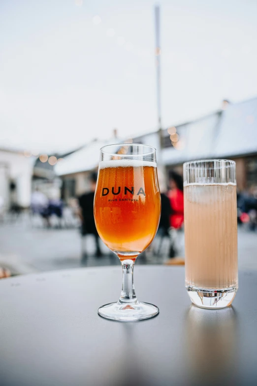 two glasses are sitting on a table outside