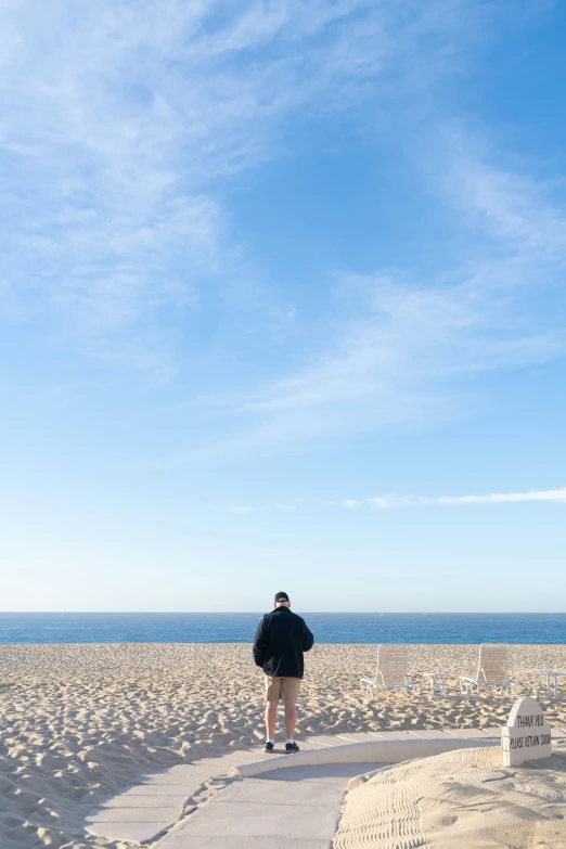 a person standing on top of a beach near the ocean