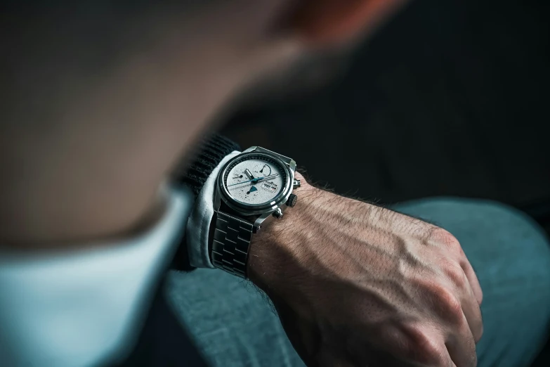 a man in a suit holding his watch