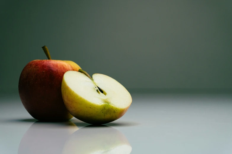 the whole apple next to an half of it's cut in half