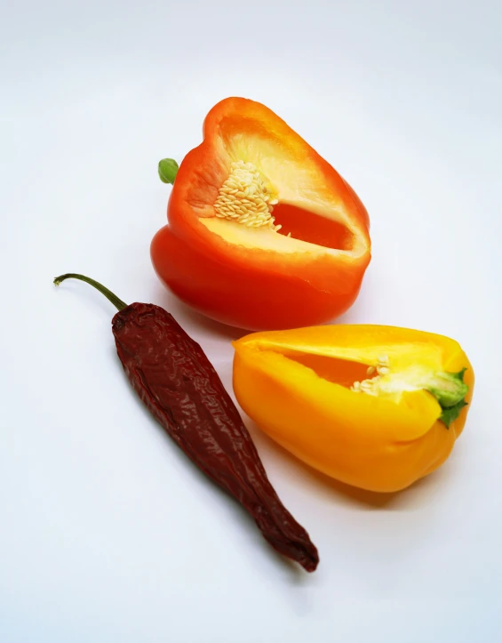 three pieces of tomato, an orange pepper, and half a red pepper are arranged together