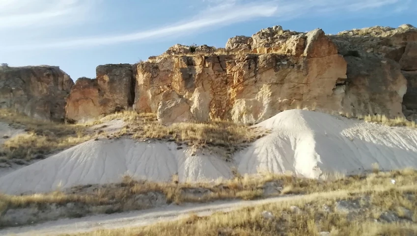 the mountains are covered with sand and green grass