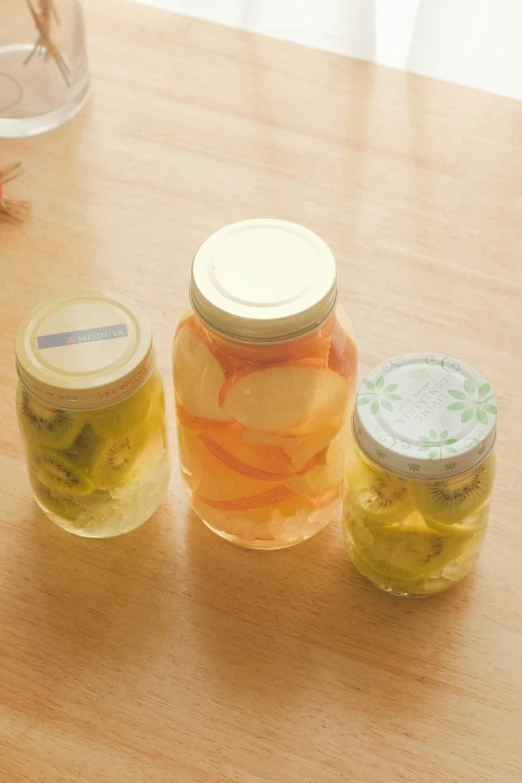 three jars of pickles sitting on top of a table