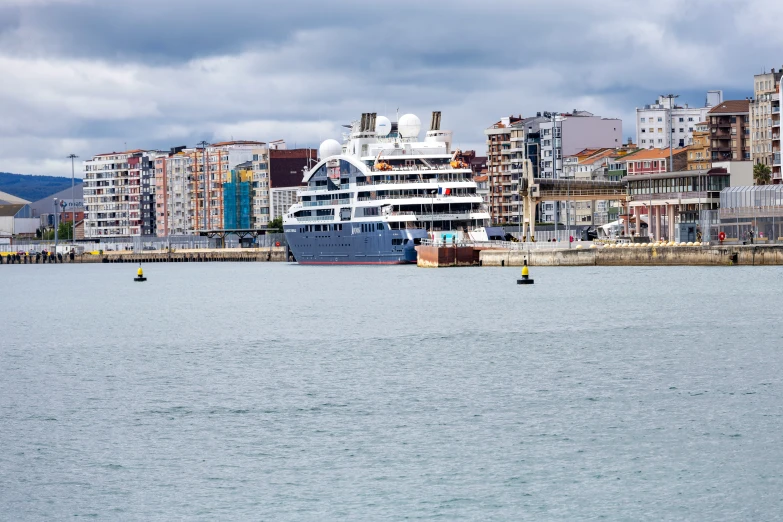 a large boat sailing in front of a building on the water