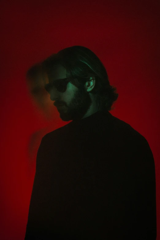 man wearing headphones in black jacket against red background