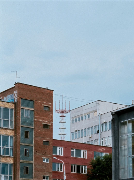 tall buildings are seen behind a fence with signs on it