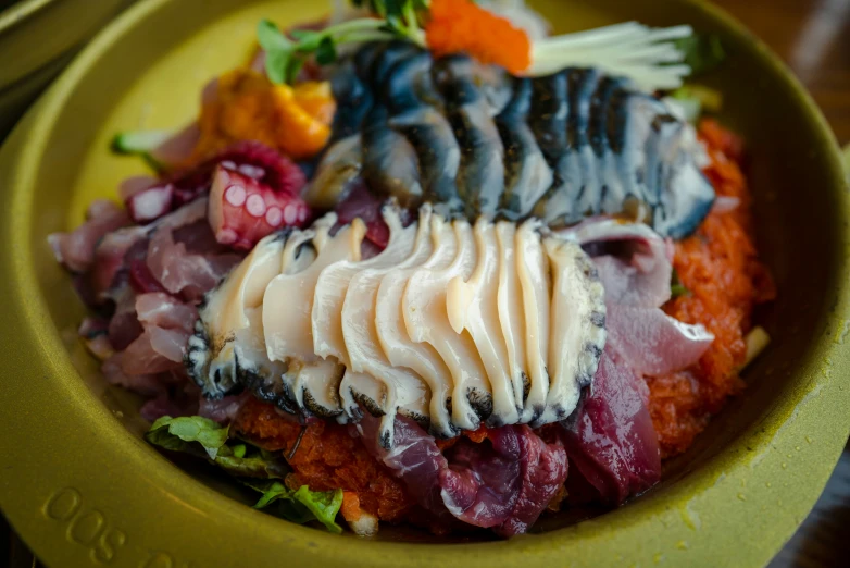 a plate topped with meat and vegetables covered in white sauce