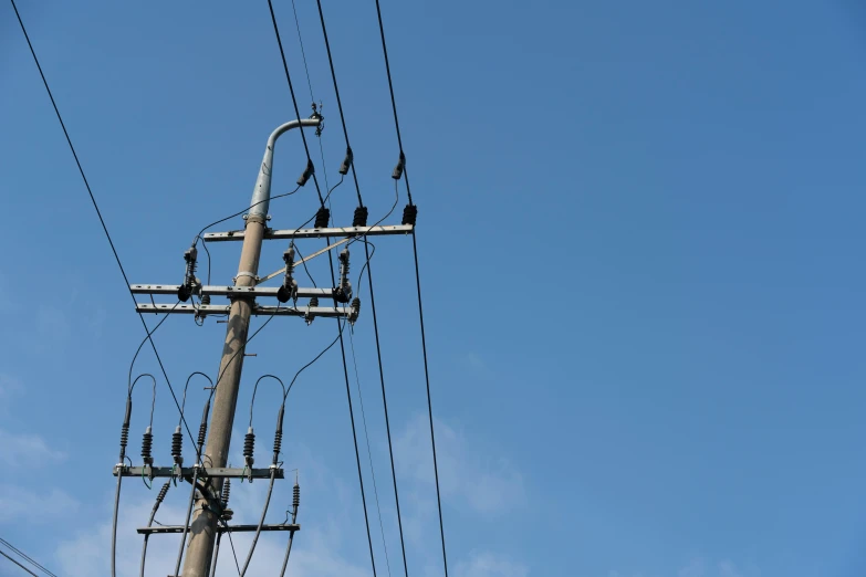 telephone poles in the middle of the blue sky