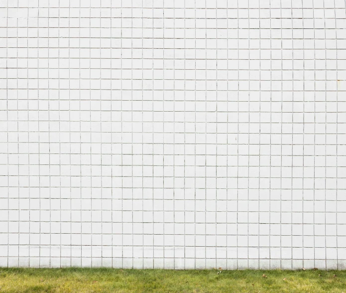 a man walking down a grassy slope next to a cement building