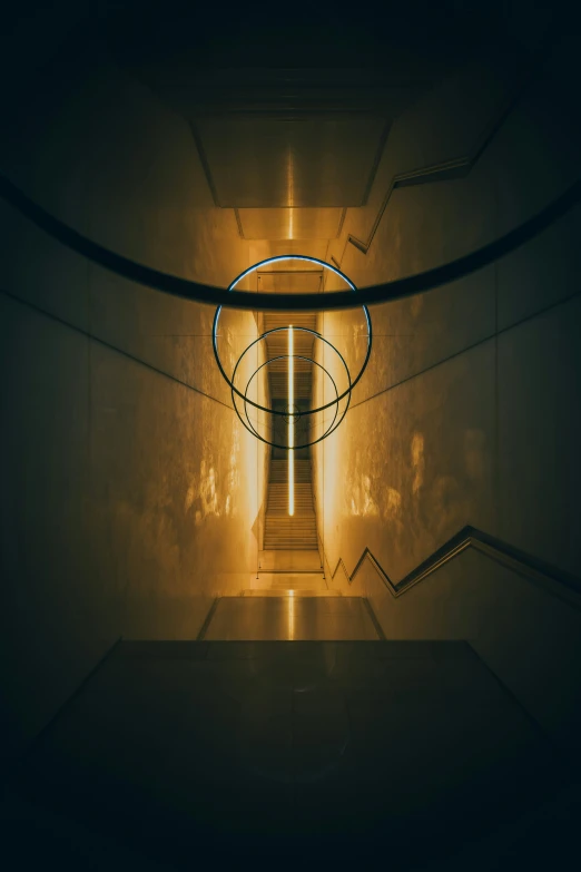 stairs leading down to a light in a stairwell