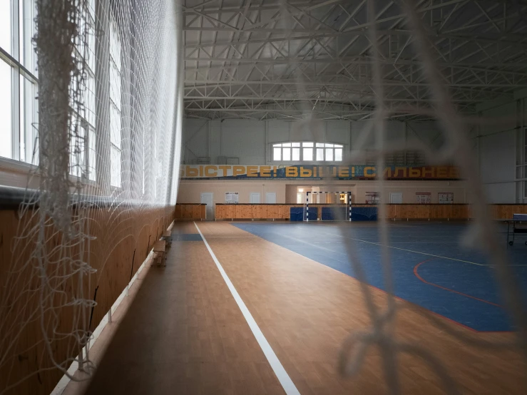 the inside of a building, with a tennis court