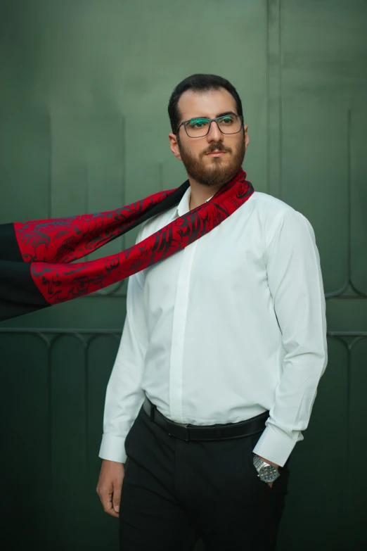 a man wearing glasses and wearing a white shirt and red scarf