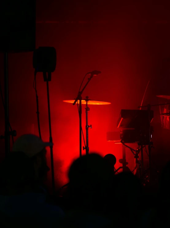 red light shining through two microphones at a music festival