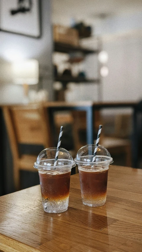 a couple of glasses with straws on a table