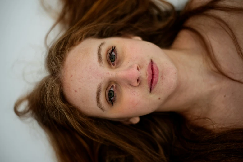 a beautiful young woman laying down on the floor