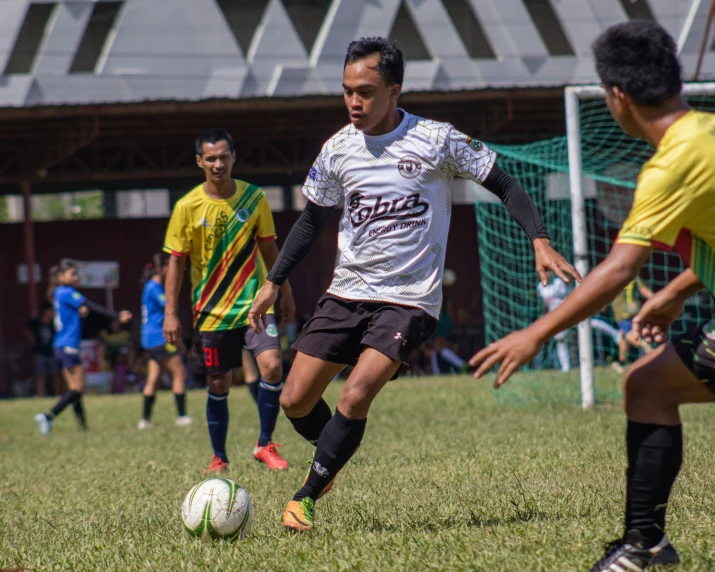 a group of men kicking a soccer ball around a field