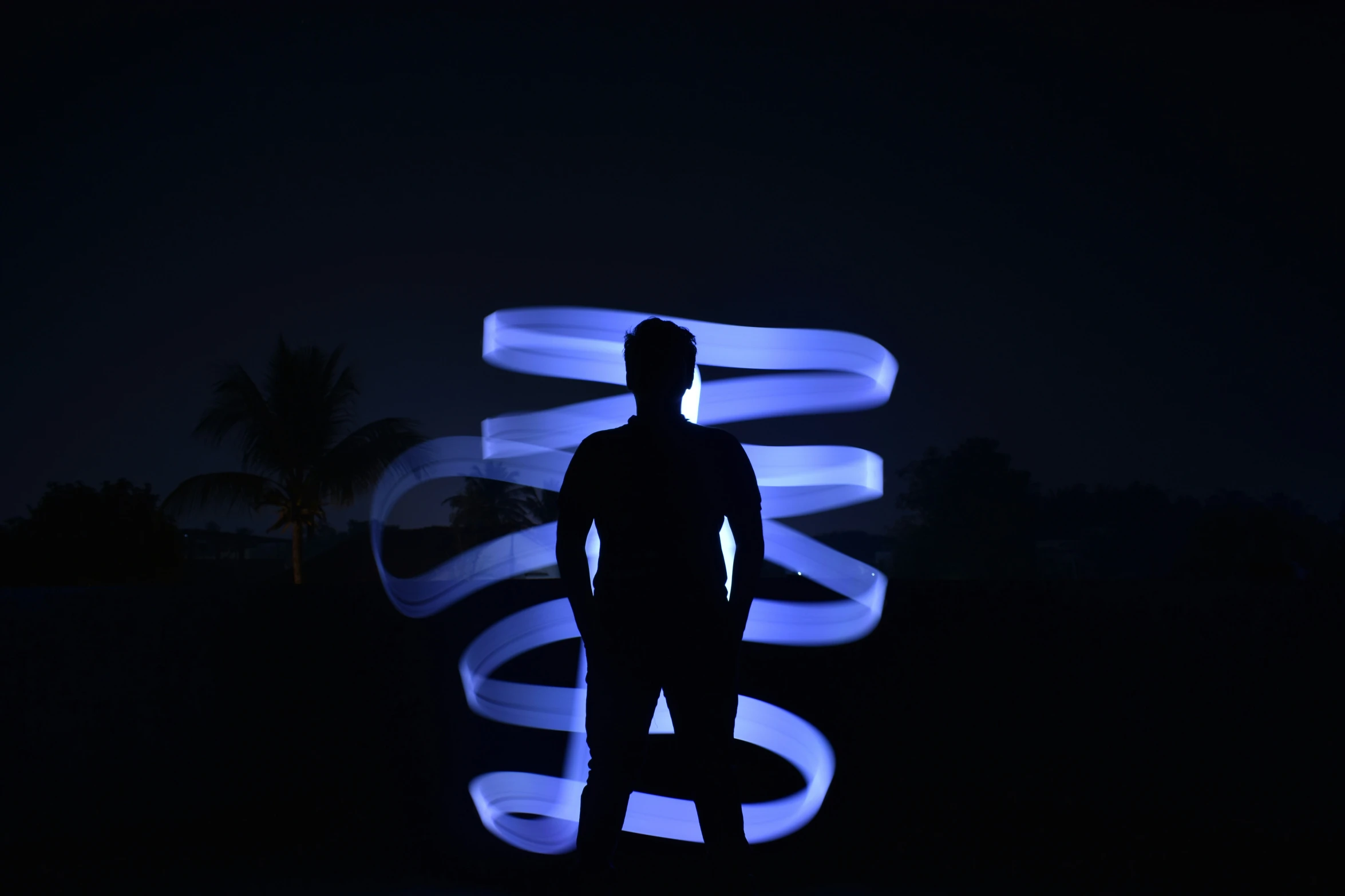 a man is silhouetted against blue lights