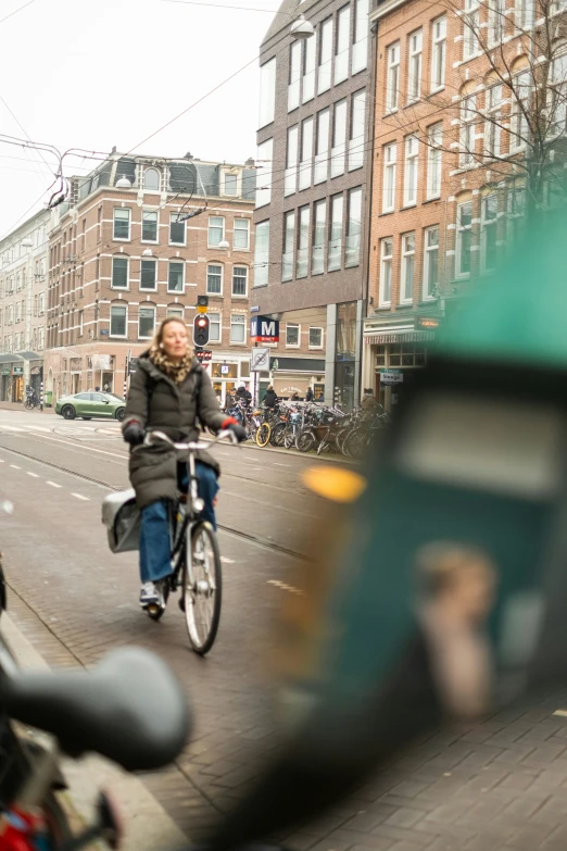 a woman is riding a bicycle down the street