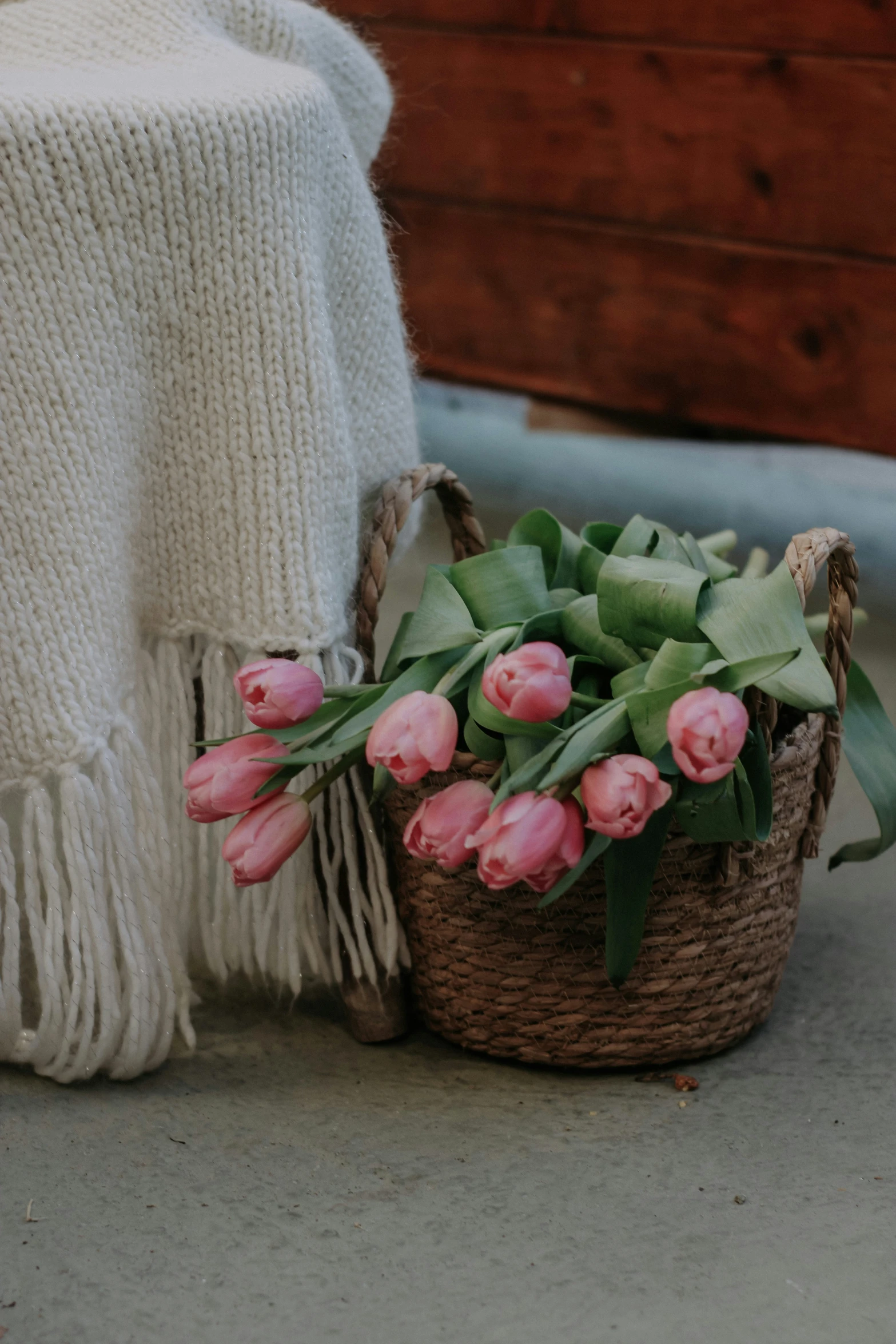 a basket with pink flowers on the ground