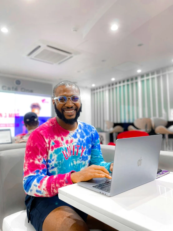 a man that is sitting down with a laptop