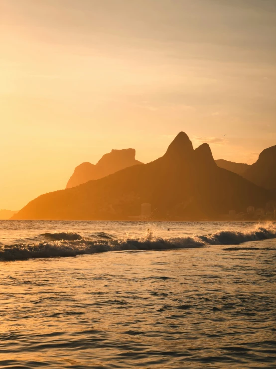 a sunset scene shows the mountains that rise above the ocean