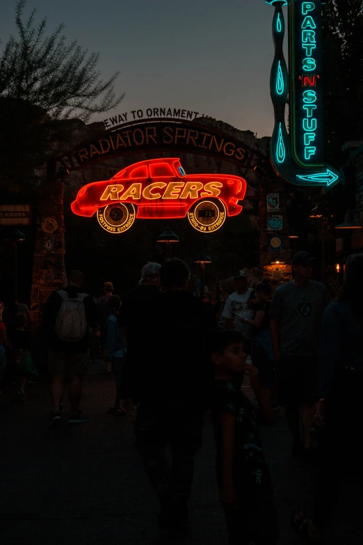 a couple people are walking near some neon signs